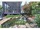 Beautiful backyard pond and waterfall feature lush landscaping and views from porch at 29 Fern Leaf Ct, Dallas, GA 30157