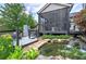 Backyard pond and waterfall feature lush greenery and peaceful views from screened in porch at 29 Fern Leaf Ct, Dallas, GA 30157