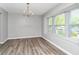 Spacious dining room with attractive light fixture, wood flooring, and ample natural light at 5477 Hedgeflower Ct, Stone Mountain, GA 30088