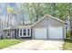 Exterior of a light grey home with two-car garage and beautiful front lawn at 5477 Hedgeflower Ct, Stone Mountain, GA 30088