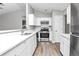 Modern kitchen featuring white cabinets, stainless steel appliances, and sleek countertops at 5477 Hedgeflower Ct, Stone Mountain, GA 30088