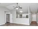 Open-concept living area with a view of the kitchen and entry hall; light gray walls and laminate floors at 5477 Hedgeflower Ct, Stone Mountain, GA 30088