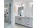 Bathroom with double sinks, gray cabinets, quartz countertop, and walk-in shower at 95 Wilder Ridge Way, Lawrenceville, GA 30044