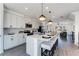 Modern kitchen boasts white cabinets, quartz countertops, stainless steel appliances and a stylish island with seating at 95 Wilder Ridge Way, Lawrenceville, GA 30044