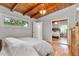 View of a bedroom with hardwood floors, wood beam ceiling, and mirrored closet doors at 3185 Laventure Dr, Chamblee, GA 30341