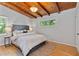 Cozy bedroom featuring a plush bed, hardwood floors, and exposed wood beam ceiling at 3185 Laventure Dr, Chamblee, GA 30341