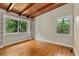 Spacious bedroom with hardwood floors, exposed wood beam ceiling, and built-in shelving at 3185 Laventure Dr, Chamblee, GA 30341