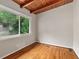 Bedroom with wood floor, wooden beam ceiling and a large window with view of outdoors at 3185 Laventure Dr, Chamblee, GA 30341