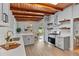 Modern kitchen with white cabinets, stainless steel appliances, quartz countertops, wood beam ceiling and floating shelves at 3185 Laventure Dr, Chamblee, GA 30341