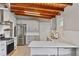 Updated kitchen with white cabinets, quartz countertops, wood beam ceiling and stainless steel appliances at 3185 Laventure Dr, Chamblee, GA 30341