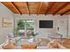 Cozy living room with a wood beam ceiling, hardwood floors, and a view to the carport at 3185 Laventure Dr, Chamblee, GA 30341