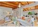 Open-concept living room features wood beam ceiling, hardwood floors, neutral decor, and a seamless flow to the kitchen and dining area at 3185 Laventure Dr, Chamblee, GA 30341