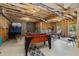 Unfinished basement with exposed wooden beams and game equipment at 5330 Cole Creek Ln, Cumming, GA 30040