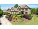 View of brick home with three-car garage, manicured lawn, and mature landscaping at 5330 Cole Creek Ln, Cumming, GA 30040