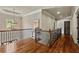 Upstairs hallway boasts wood floors, iron railing, and tray ceilings at 5330 Cole Creek Ln, Cumming, GA 30040