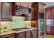 Close up shot of a gourmet kitchen featuring granite countertops, dark wood cabinetry, and stainless appliances at 5330 Cole Creek Ln, Cumming, GA 30040