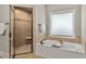Main bathroom features a walk-in shower and soaking tub with natural light at 5330 Cole Creek Ln, Cumming, GA 30040