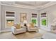 Sitting area with neutral armchairs, windows, and bamboo shades at 5330 Cole Creek Ln, Cumming, GA 30040