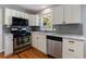 Updated kitchen boasts stainless steel appliances, white cabinets, and granite countertops, creating a stylish cooking space at 1019 Magbee Se Dr, Smyrna, GA 30080