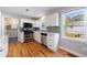 Modern kitchen with stainless steel appliances, white cabinets, and a window overlooking the backyard at 1019 Magbee Se Dr, Smyrna, GA 30080