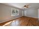 Bright living room featuring hardwood floors, a ceiling fan, and plenty of natural light from a large window at 1019 Magbee Se Dr, Smyrna, GA 30080