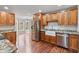 Kitchen featuring wooden cabinets, granite counters, stainless appliances, and wood flooring at 1340 Summer Lake Ter, Loganville, GA 30052
