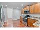 Kitchen featuring wooden cabinets, granite counters, stainless appliances, and wood flooring at 1340 Summer Lake Ter, Loganville, GA 30052