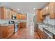 Kitchen featuring wooden cabinets, granite counters, stainless appliances, and wood flooring at 1340 Summer Lake Ter, Loganville, GA 30052