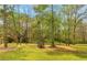 Lush green backyard with a playhouse surrounded by mature trees at 3510 Donegal Way, Snellville, GA 30039