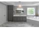 An elegant bathroom with a soaking tub, stylish vanity, and marble floors at 3510 Donegal Way, Snellville, GA 30039