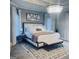 Bright main bedroom with a large bed, beautiful chandelier and soft colors at 3510 Donegal Way, Snellville, GA 30039
