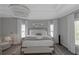 This main bedroom features an elegant chandelier, bay windows, and a neutral color palette at 3510 Donegal Way, Snellville, GA 30039
