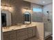 Modern bathroom featuring dual sinks, decorative mirrors, and a glass-enclosed shower at 63 Aspen Way, Dallas, GA 30157