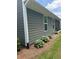 Exterior of home features gray siding and a garden alongside the house at 63 Aspen Way, Dallas, GA 30157