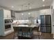 Modern kitchen with white cabinets, stainless steel appliances, and an island with seating at 63 Aspen Way, Dallas, GA 30157