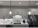 Kitchen area with large glass pendant lights above stainless steel sink and appliances at 63 Aspen Way, Dallas, GA 30157