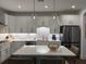 Modern kitchen with stainless steel appliances, white cabinets, island, and stylish pendant lighting at 63 Aspen Way, Dallas, GA 30157