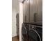 Laundry room featuring gray cabinets and a modern washer and dryer at 63 Aspen Way, Dallas, GA 30157