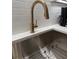 Stainless steel sink with bronze fixtures and subway tile backsplash at 63 Aspen Way, Dallas, GA 30157