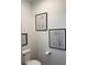 Neutral powder room showcases a toilet and stylish art to complement the space at 63 Aspen Way, Dallas, GA 30157