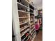 Custom walk-in closet features extensive shelving for organized shoe storage, providing practical solutions for maintaining a tidy wardrobe at 63 Aspen Way, Dallas, GA 30157