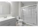 Neutral bathroom featuring a single vanity, a framed mirror, toilet, and a glass enclosed shower at 6710 Grayland Dr, Douglasville, GA 30135