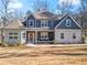 Charming two-story home featuring stone accents, blue siding, and a welcoming front porch with seating at 6710 Grayland Dr, Douglasville, GA 30135