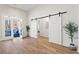 Spacious living room with hardwood floors, sliding barn doors, and access to an outdoor patio with wooded views at 6710 Grayland Dr, Douglasville, GA 30135