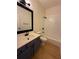 Well-lit bathroom with white tile, modern vanity, and a shower-tub combination at 5760 Old Carriage Dr, Atlanta, GA 30349