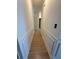 Hallway with white walls, decorative trim, and beautiful light wood-look floors at 5760 Old Carriage Dr, Atlanta, GA 30349