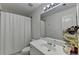 Well-lit bathroom features a vanity with sink, mirror, and shower with white curtain at 1213 Harris Commons Place, Roswell, GA 30076