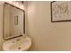 Bathroom featuring pedestal sink, framed mirror, decorative lighting, and modern accents at 1213 Harris Commons Place, Roswell, GA 30076