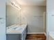 Bathroom with a double sink vanity with a large mirror and wood grain floors and a shower with glass door at 167 Fairview Oak Trl, Dallas, GA 30157