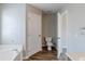 Bathroom featuring a soaking tub, toilet, tile floor, and open doorway to another section of the bathroom at 167 Fairview Oak Trl, Dallas, GA 30157